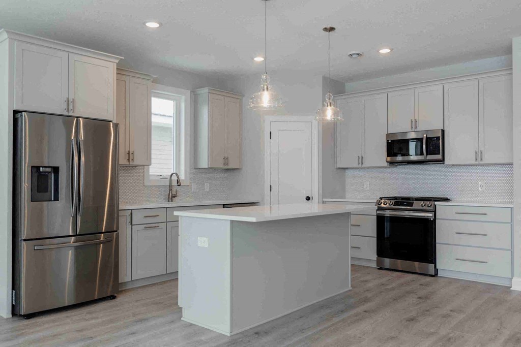 a white kitchen with stainless steel appliances and white cabinets