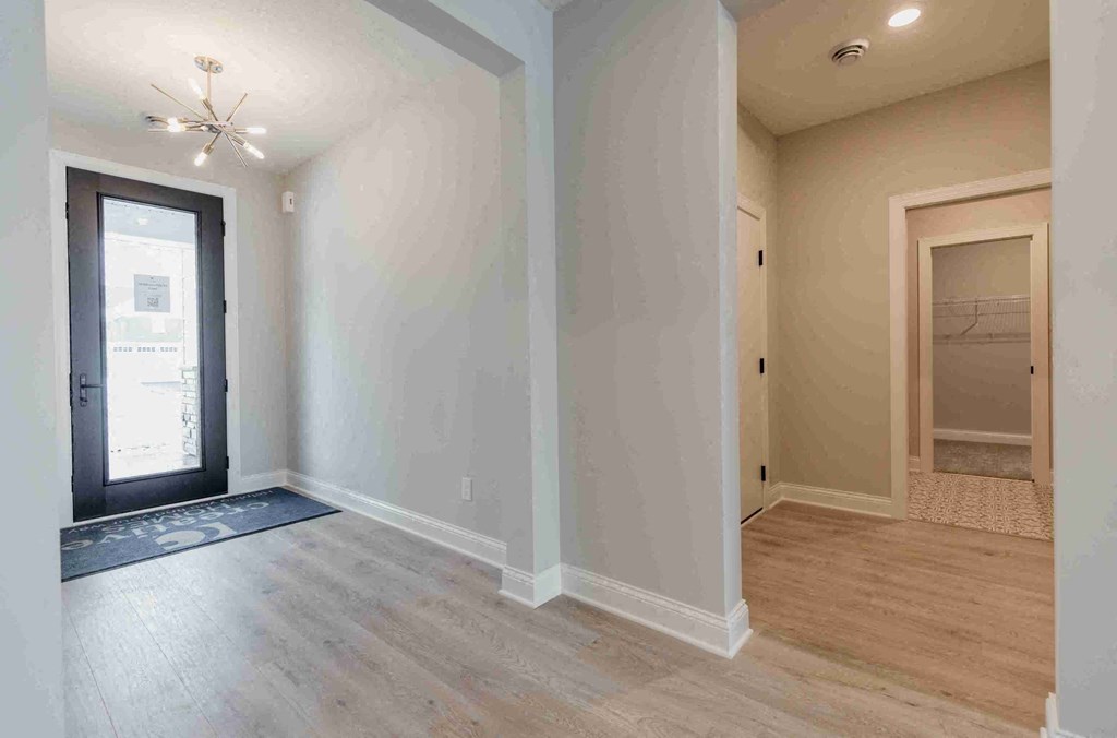 an empty living room with a door to a closet
