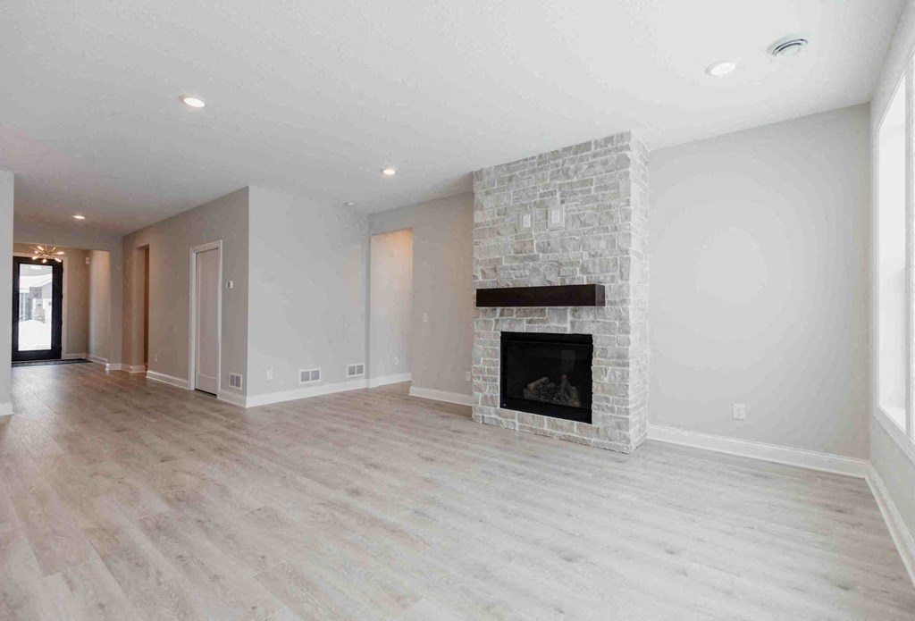 a living room with a fireplace and a wooden floor