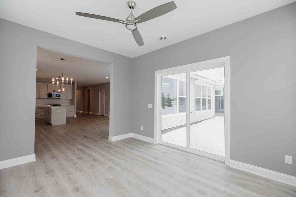 an empty living room with a ceiling fan