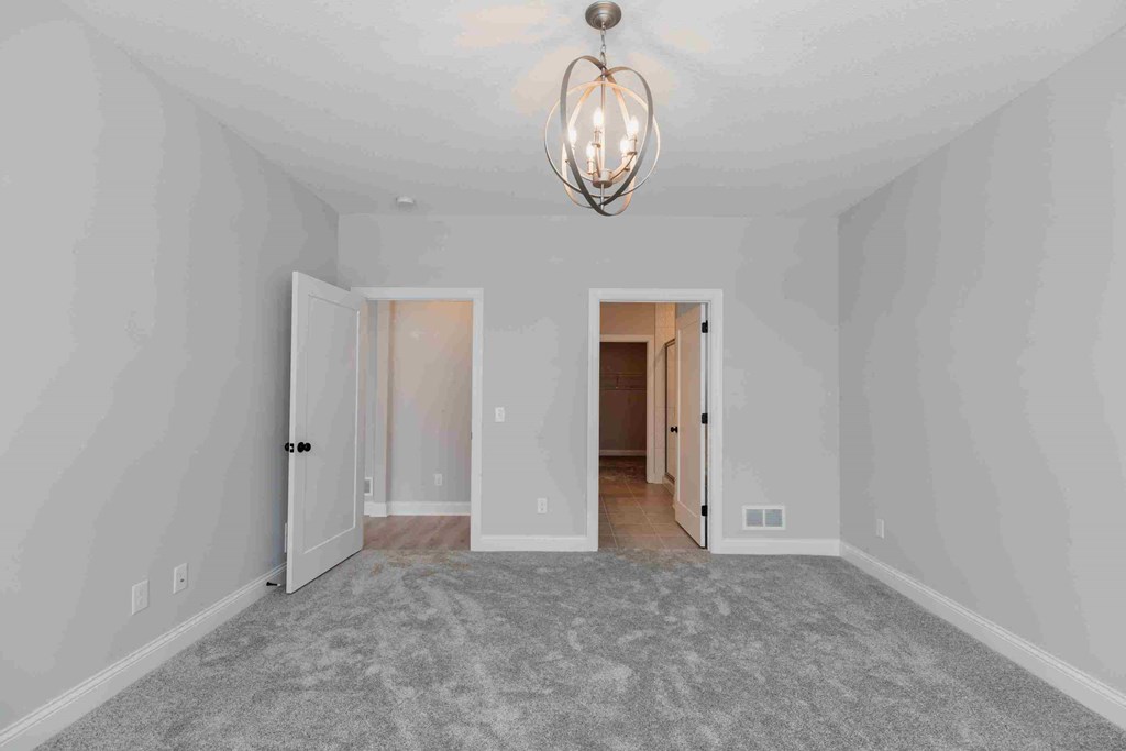 a bedroom with a carpeted floor and a light fixture