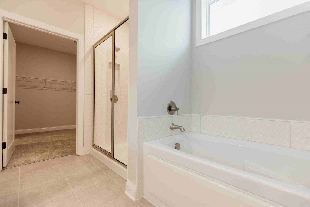 a bathroom with a tub and a shower in it