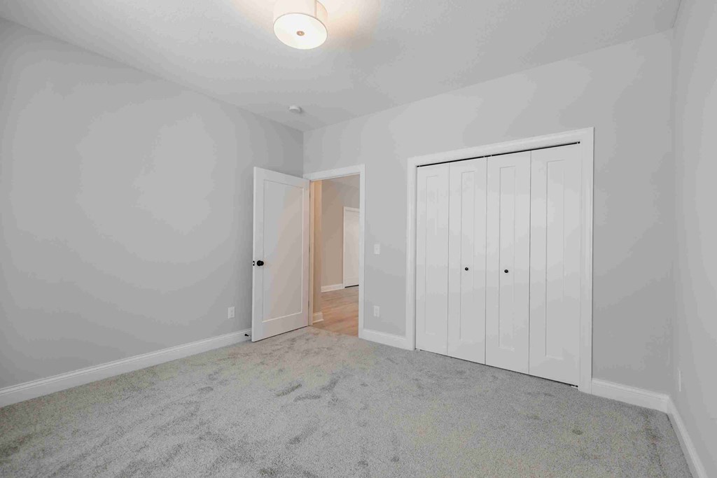 a bedroom with two closets and a carpeted floor