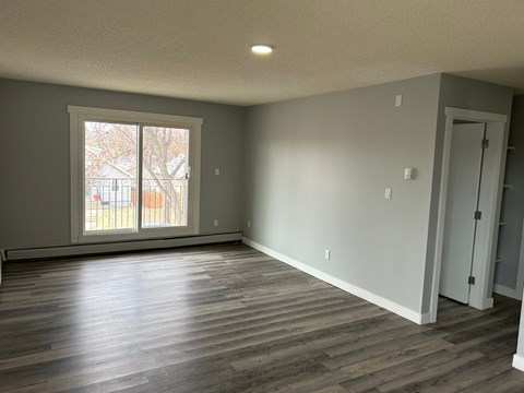 a living room with a large window and wooden floors