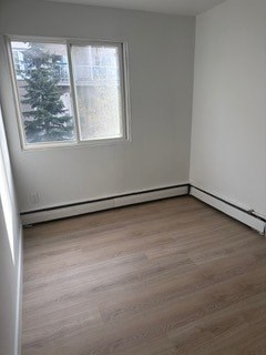 A room with a window and wooden flooring.