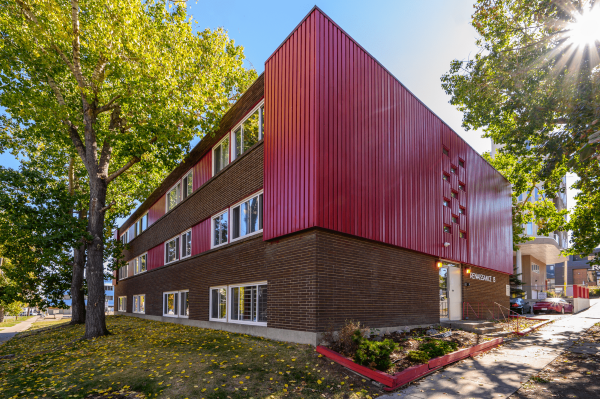 A red building with a tree in front of it.
