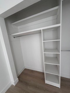 A white shelving unit in a room with wooden flooring.