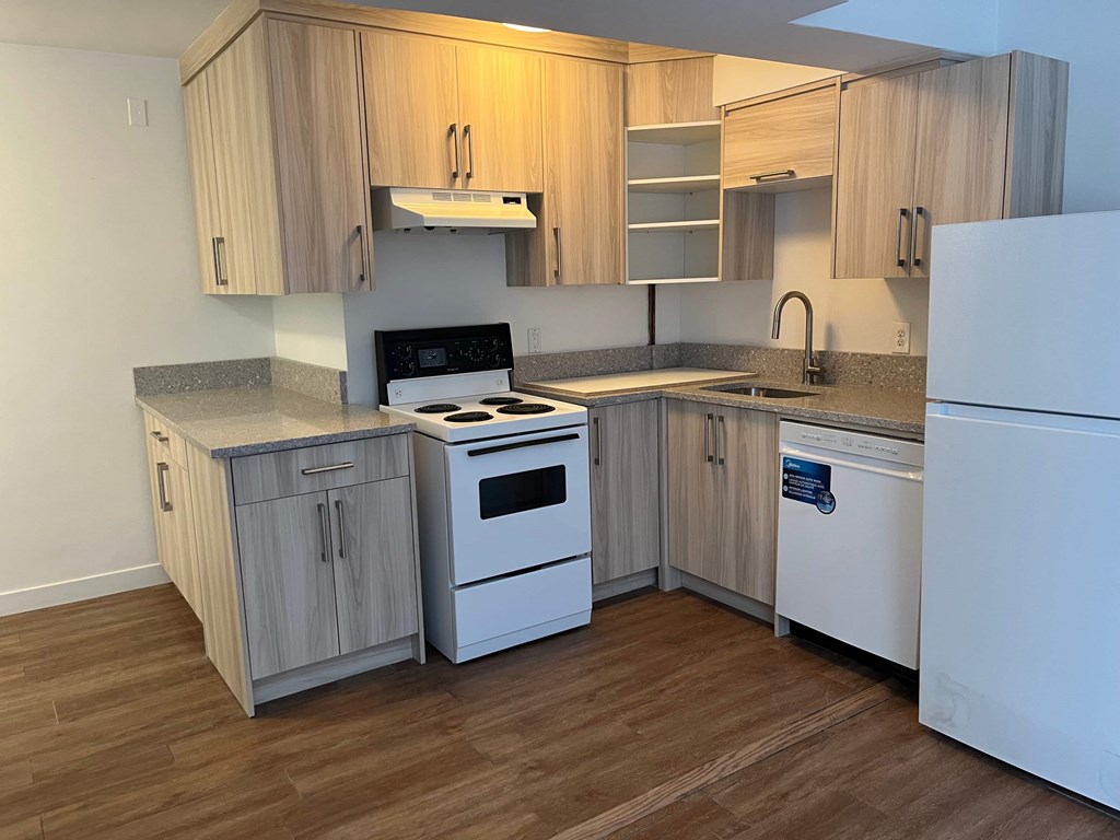 A kitchen with wooden cabinets and white appliances.