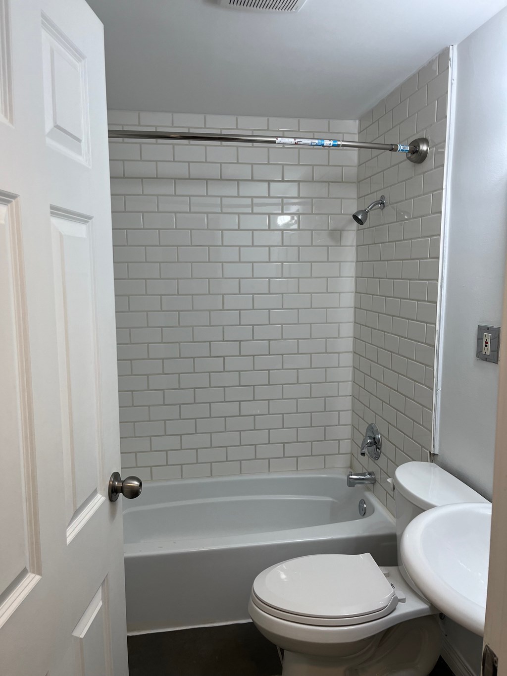 A white toilet sits next to a white sink in a bathroom.
