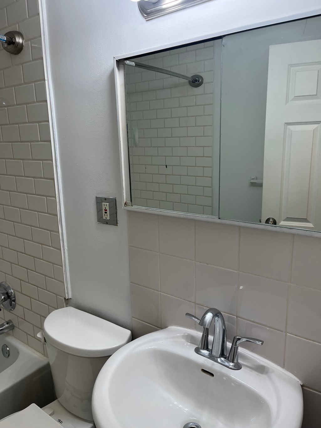 A white toilet sits next to a white sink in a bathroom.
