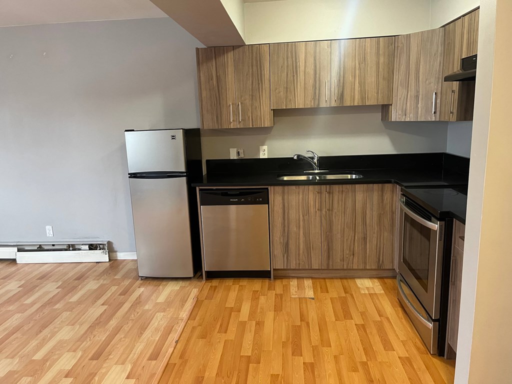 A kitchen with wooden floors and stainless steel appliances.