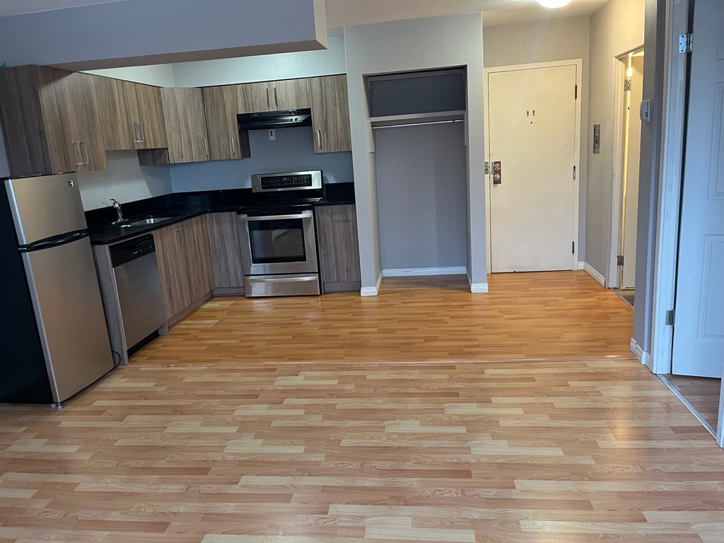 A kitchen with wooden floors and a refrigerator.