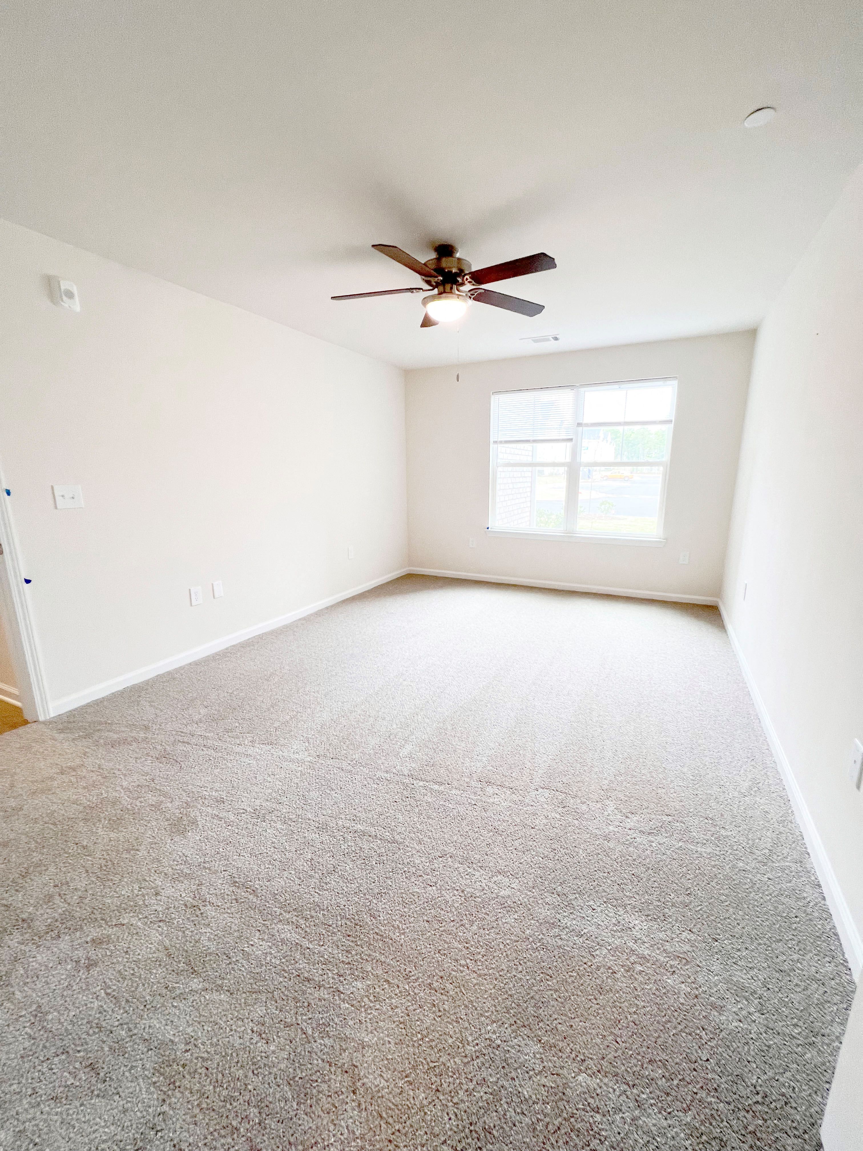 an empty room with a ceiling fan in it