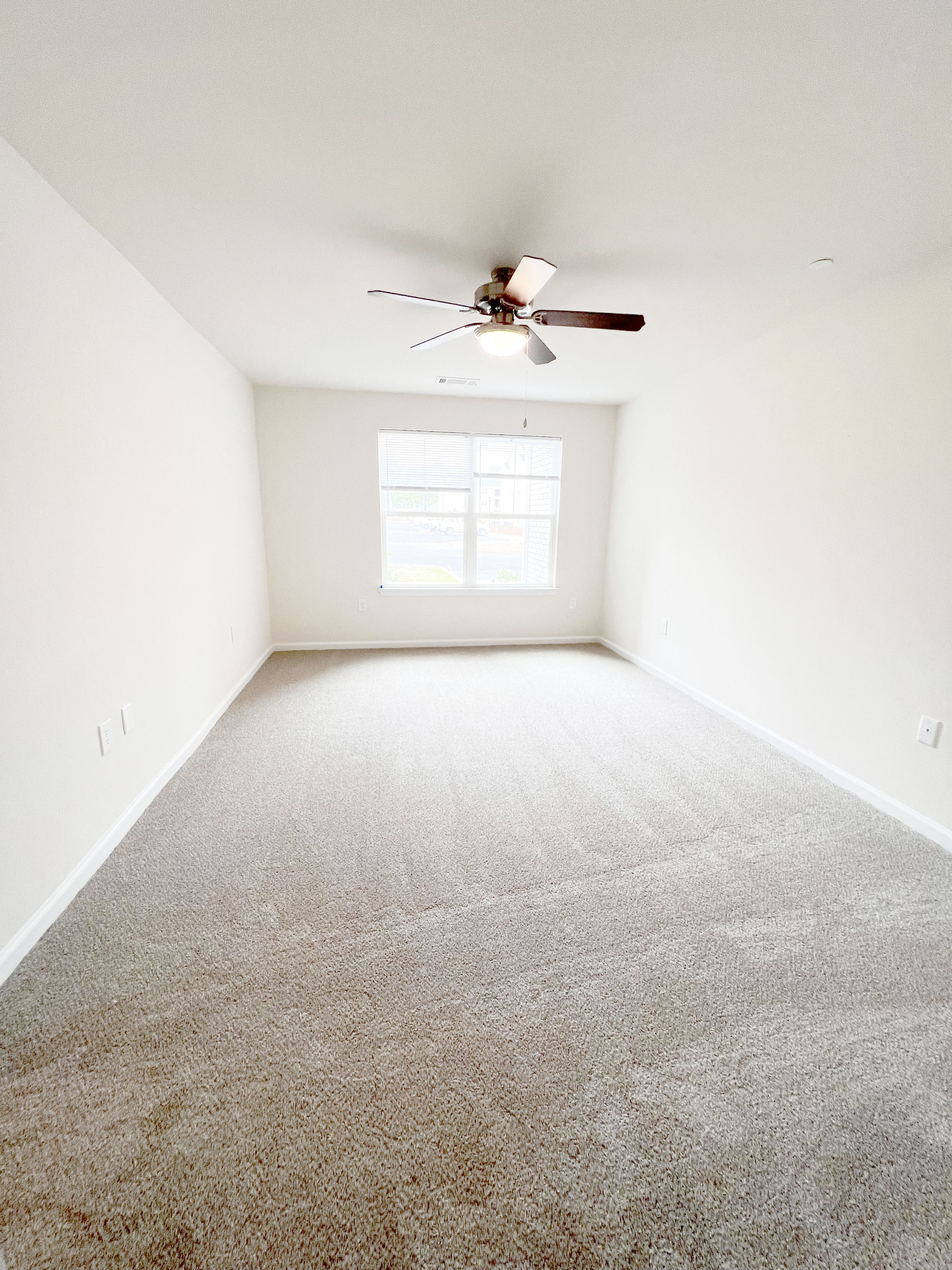 an empty room with a ceiling fan in it