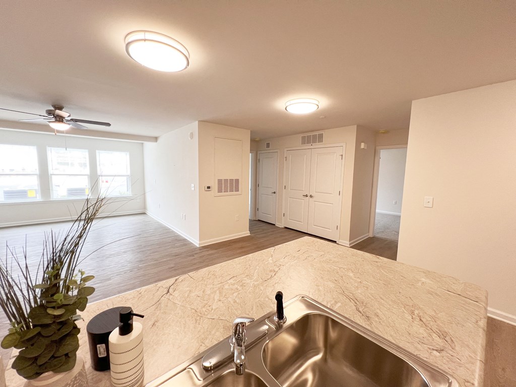 the view of a kitchen and living room from the sink in a new home