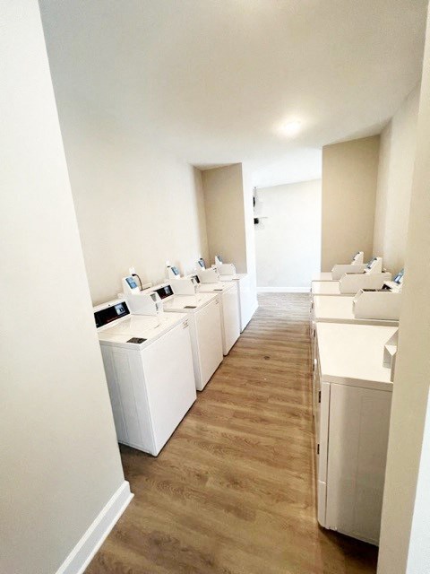 a row of white washing machines in an empty room