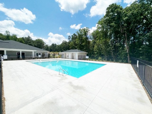 a swimming pool with a fence around it next to a house