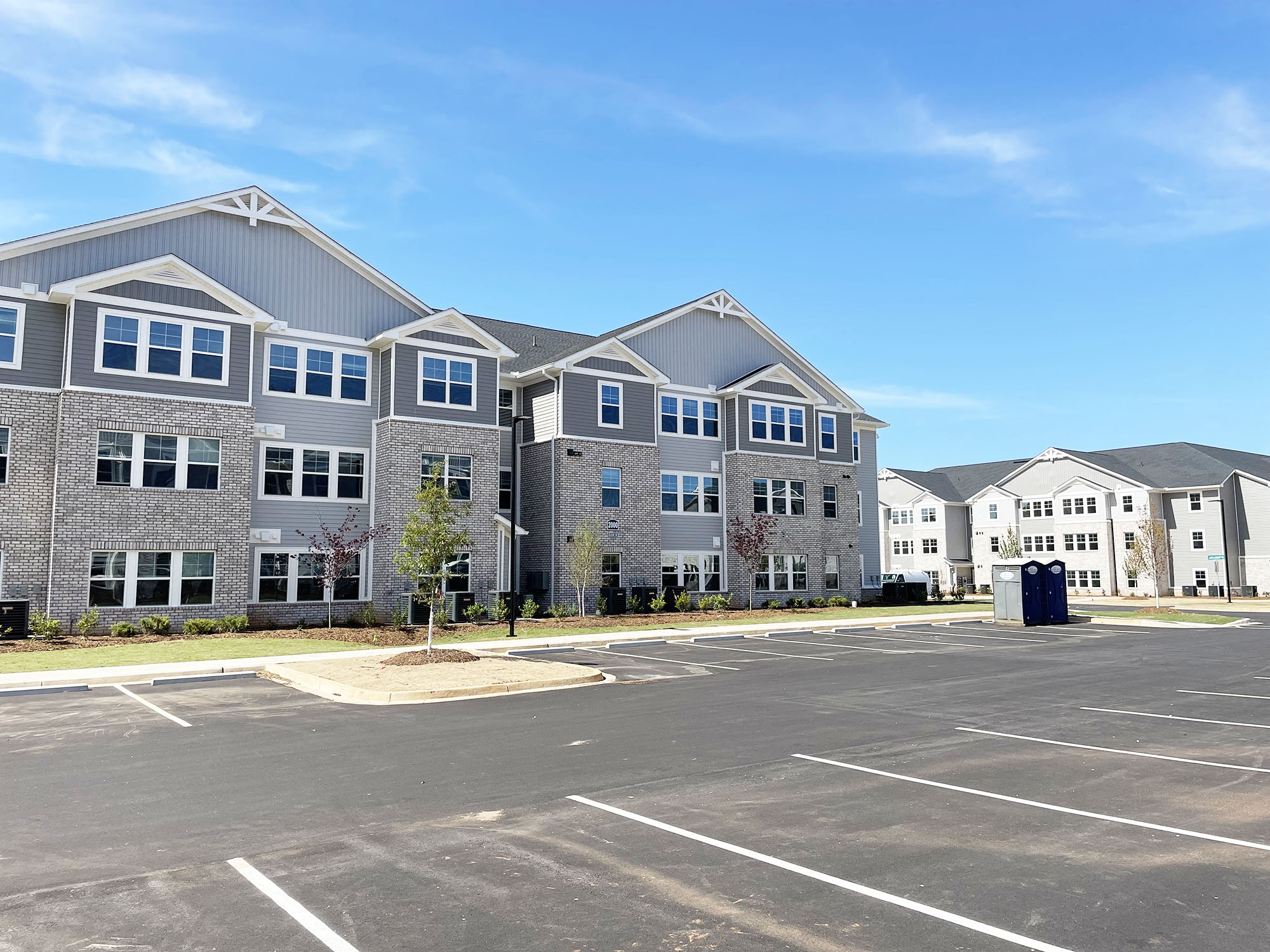 an empty parking lot in front of an apartment building