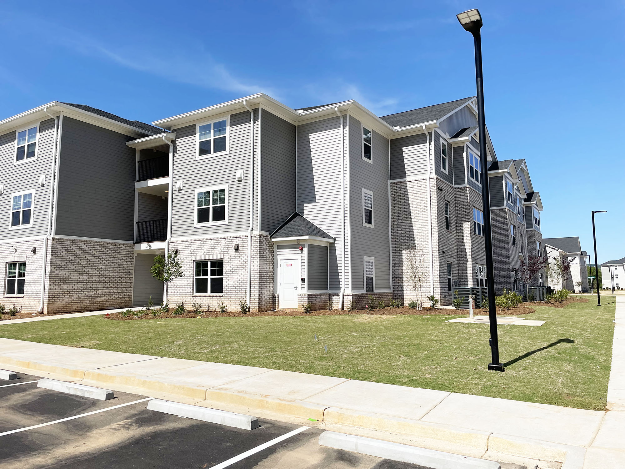 an apartment building with a lawn and a street light