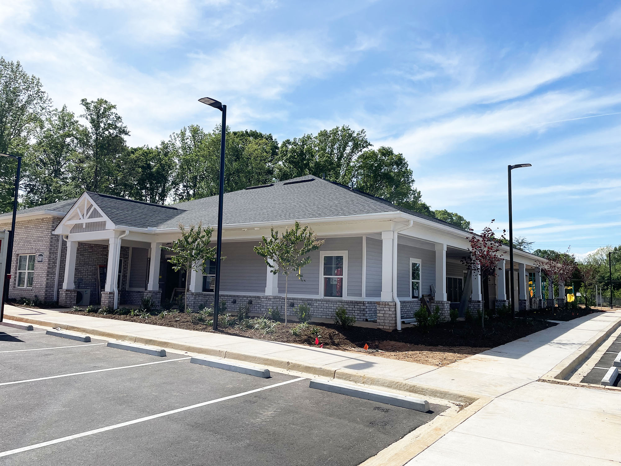 a building with a parking lot and a sidewalk in front of it