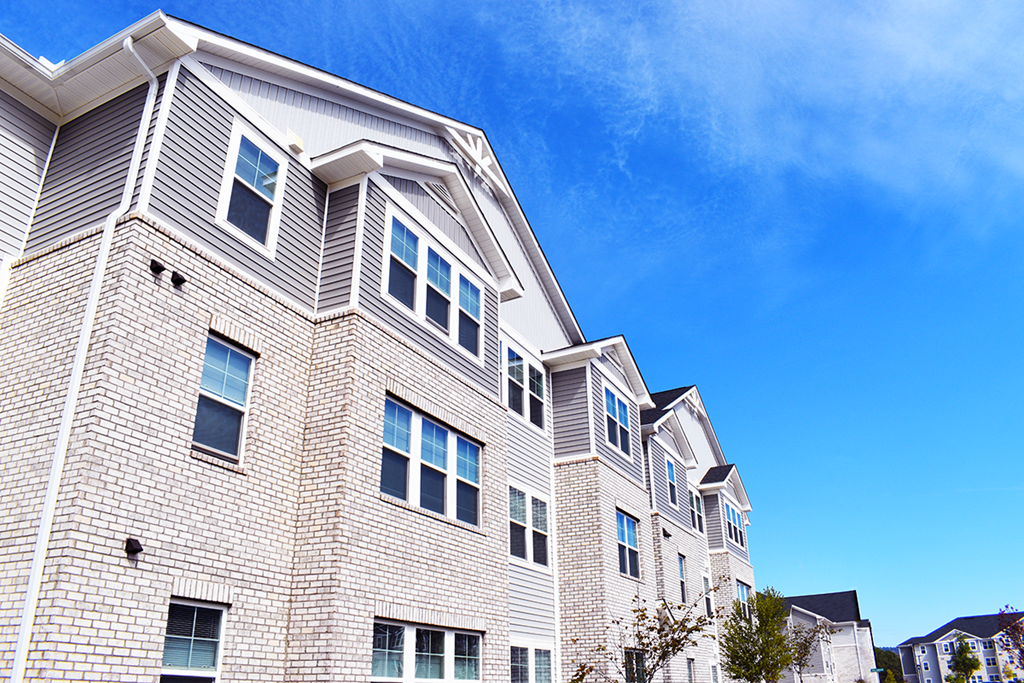 a white brick building with windows against a blue sky