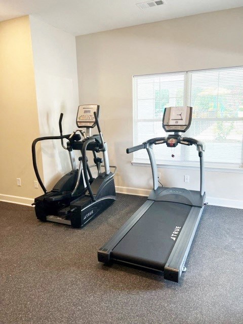 two exercise machines in an empty gym room