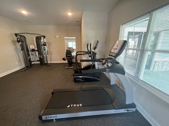 a home gym with exercise equipment and a large window