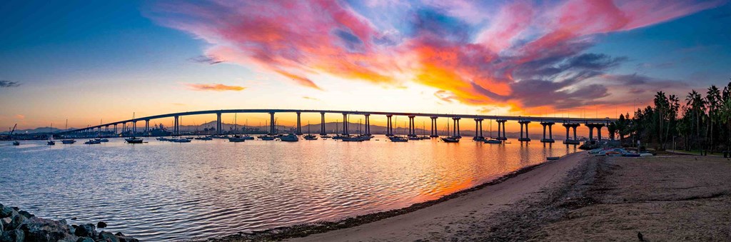 a colorful sunset over a bridge over a body of water