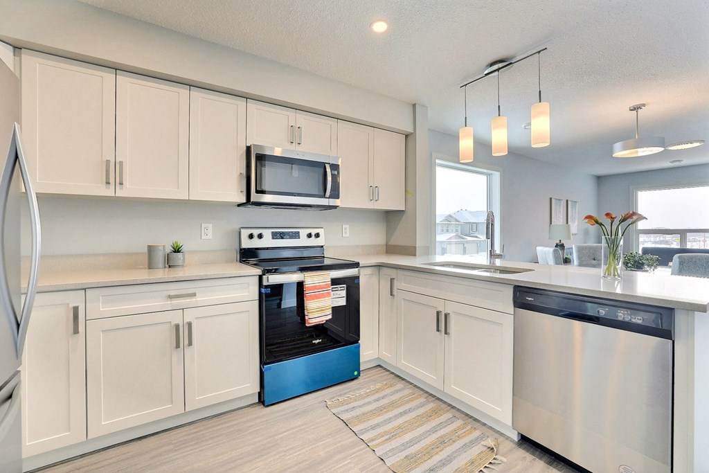 a kitchen with white cabinets and stainless steel appliances