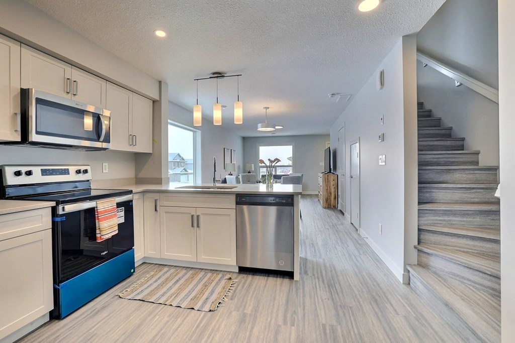 an open kitchen with stainless steel appliances and white cabinets