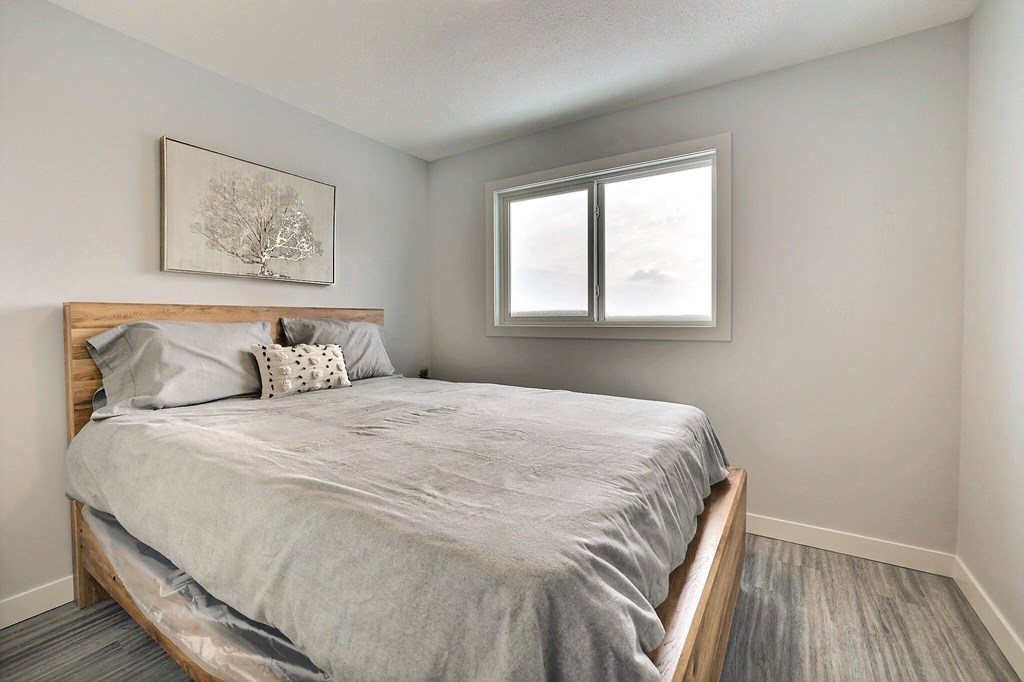 an empty bedroom with a bed and a window