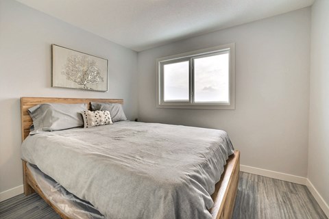 an empty bedroom with a bed and a window