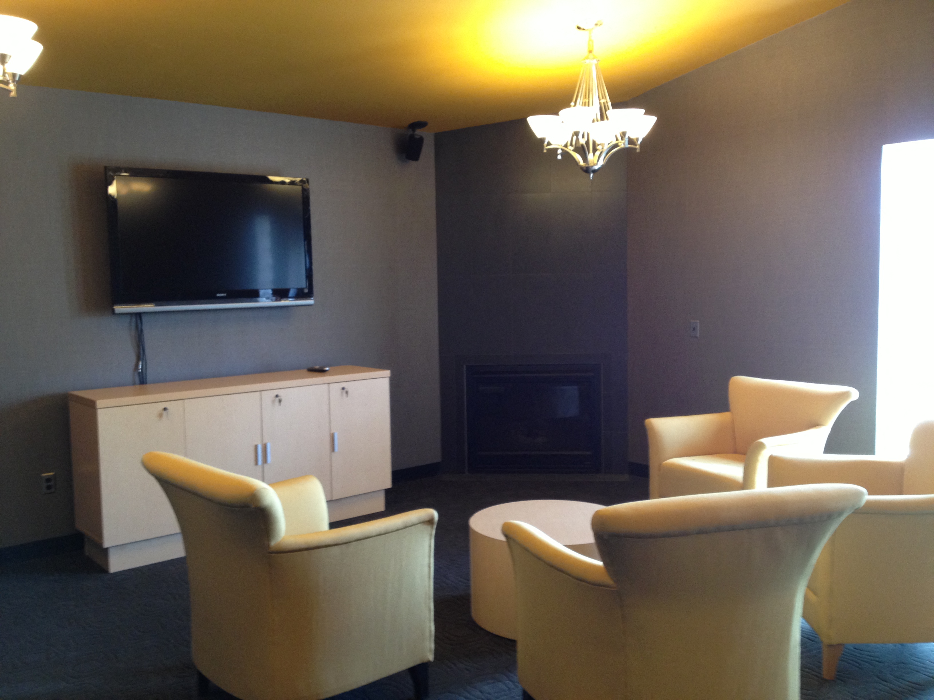 a living room with chairs and a tv