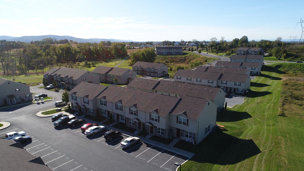 an aerial view of a group of houses in a parking lot