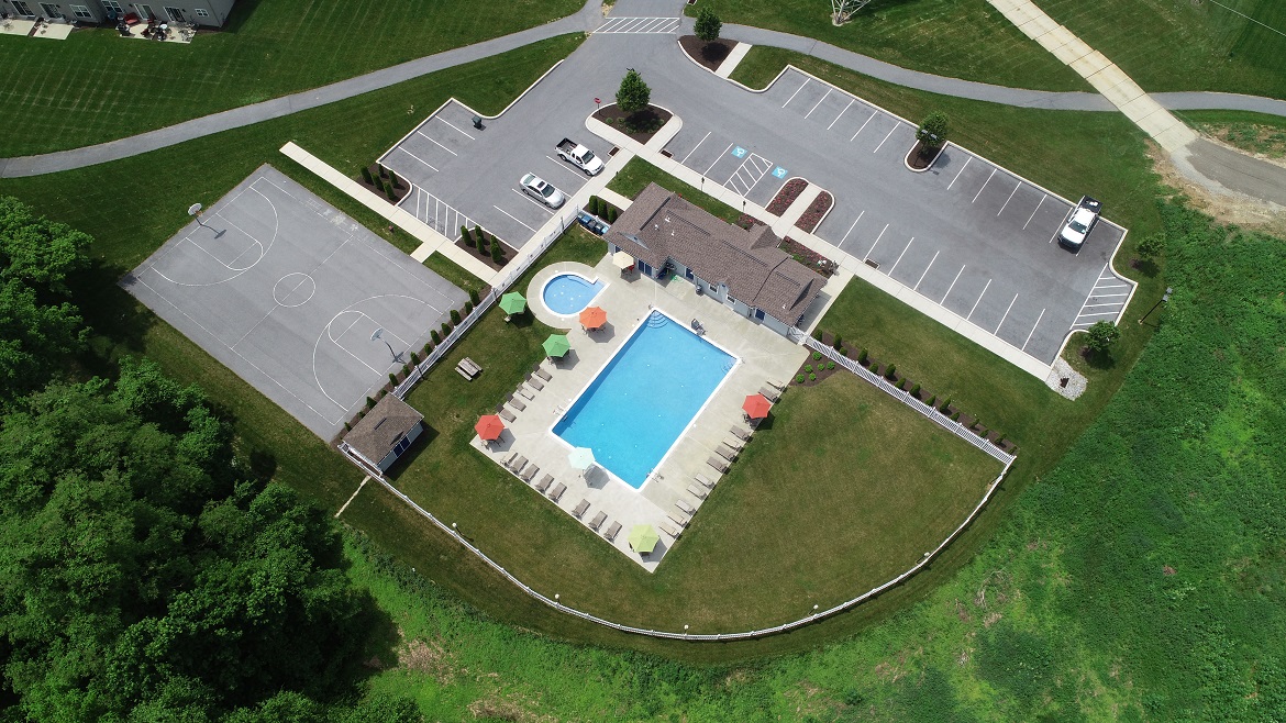 a birdseye view of a swimming pool and a house with a tennis court