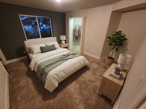 Bedroom with a queen bed, two nightstands, a dark accent wall, and an open walk-in closet.