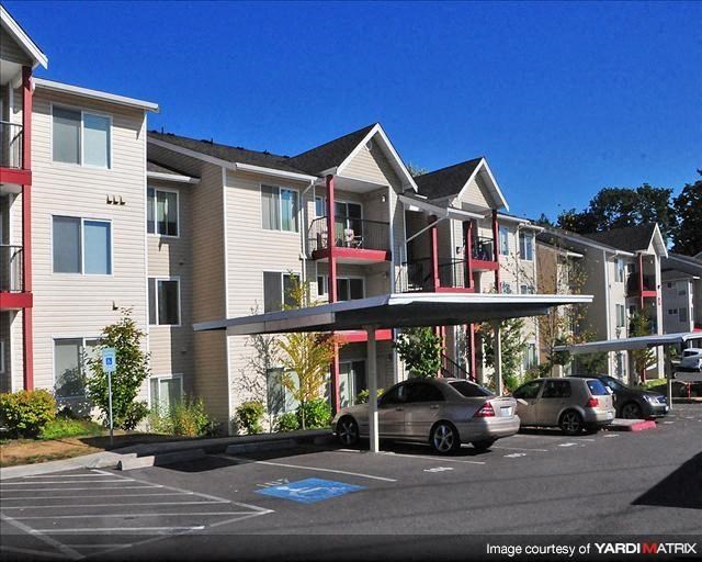 a row of houses with cars parked in a parking lot