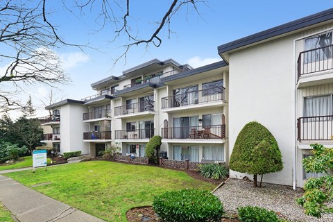 Apartment complex with a green lawn in front.