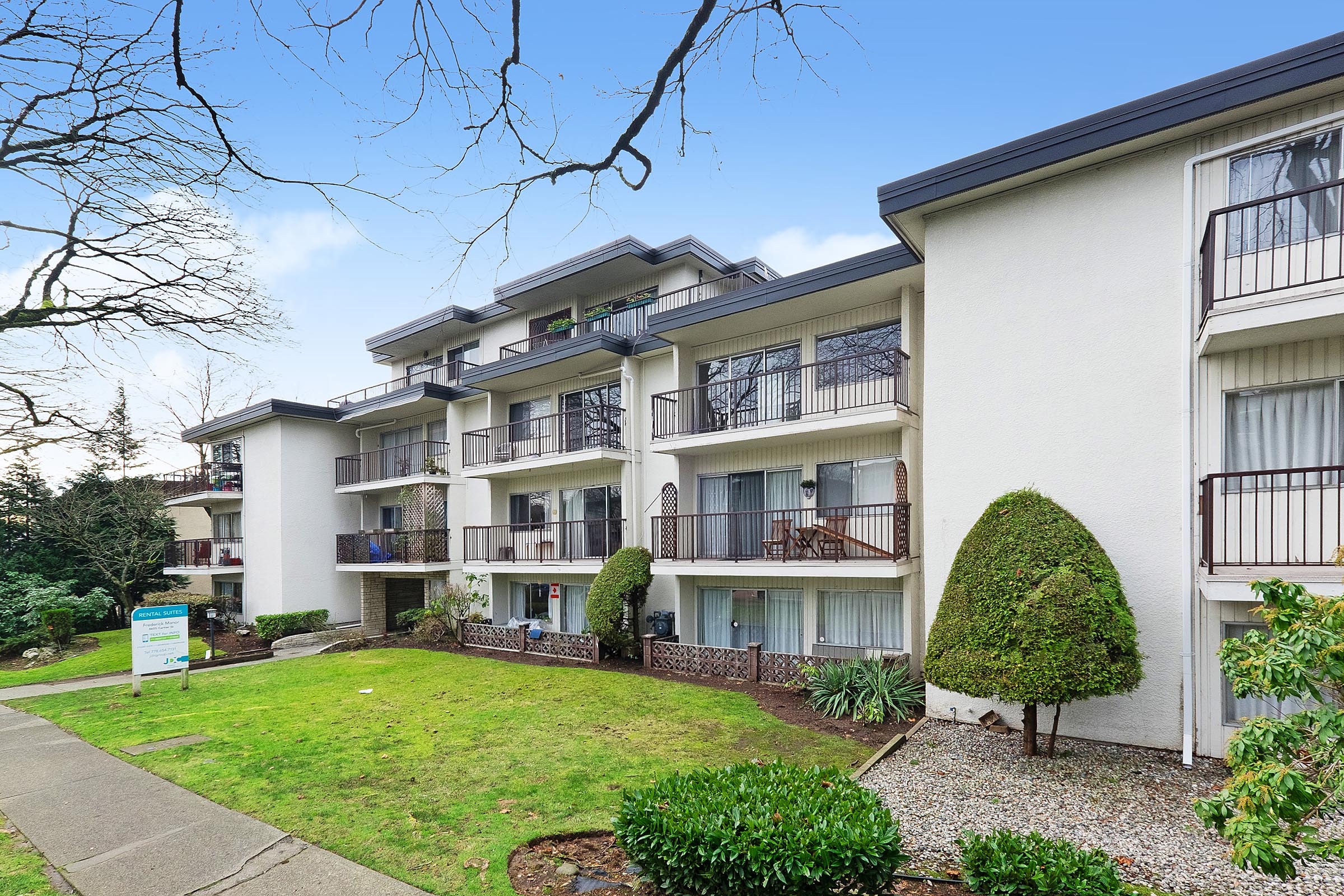 Apartment complex with a green lawn in front.