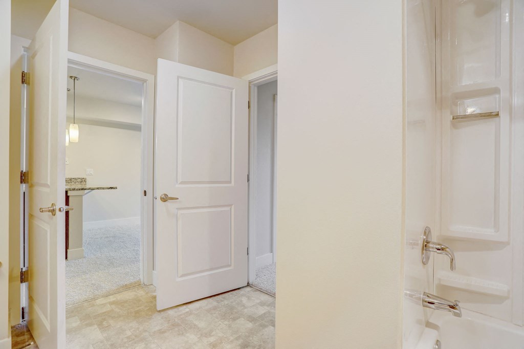 a bathroom with an open door to a closet and a shower