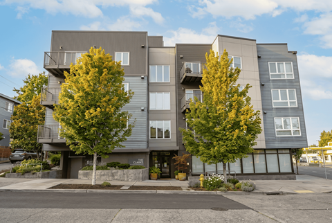 A modern apartment building with trees in front.