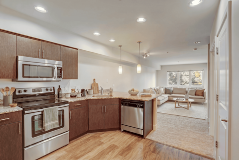 A modern kitchen with wooden cabinets and stainless steel appliances.