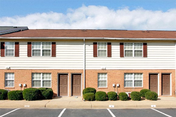 a white building with windows and a street in front of it