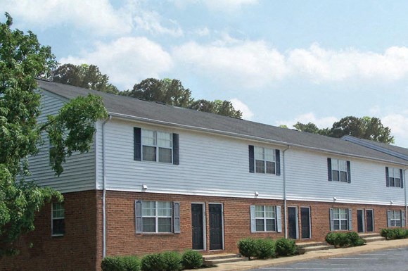 an apartment building with brick and white siding