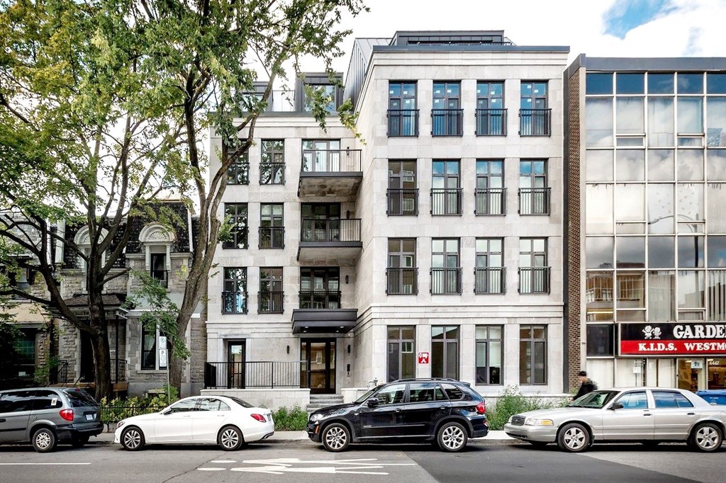 the apartment building is on the corner of a city street