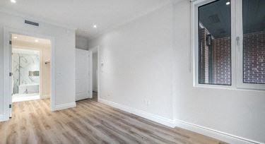 a living room with white walls and wooden floors