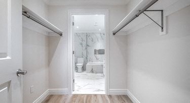 a white hallway with a door to a bathroom