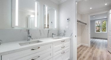a white bathroom with two sinks and a mirror