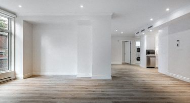 a empty living room with white walls and wooden floors