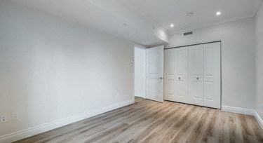 an empty room with white walls and wooden floors